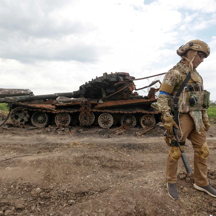 Ukrainian soldier beside destroyed Russian tank in Novodarivka, Ukraine