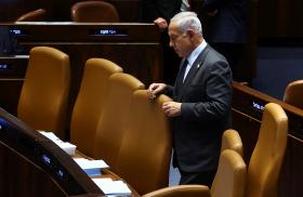 Photo of Israeli prime minister Binyamin Netanyahu standing alone in parliament.
