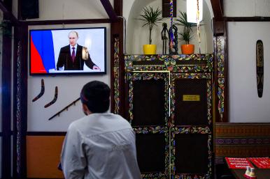 A man watches Russian president Vladimir Putin speak on television in the Crimean city of Simferopol - source: Reuters