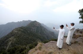 Saudi men take pictures at the Al Souda mountain - source: Reuters